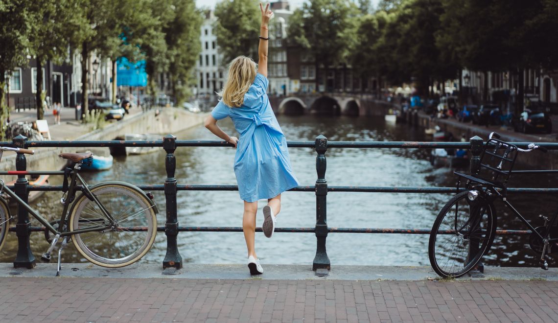 girl in a blue dress on the bridge in Amsterdam
