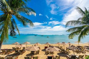 beautiful-tropical-beach-sea-ocean-with-coconut-palm-tree-umbrella-chair-blue-sky