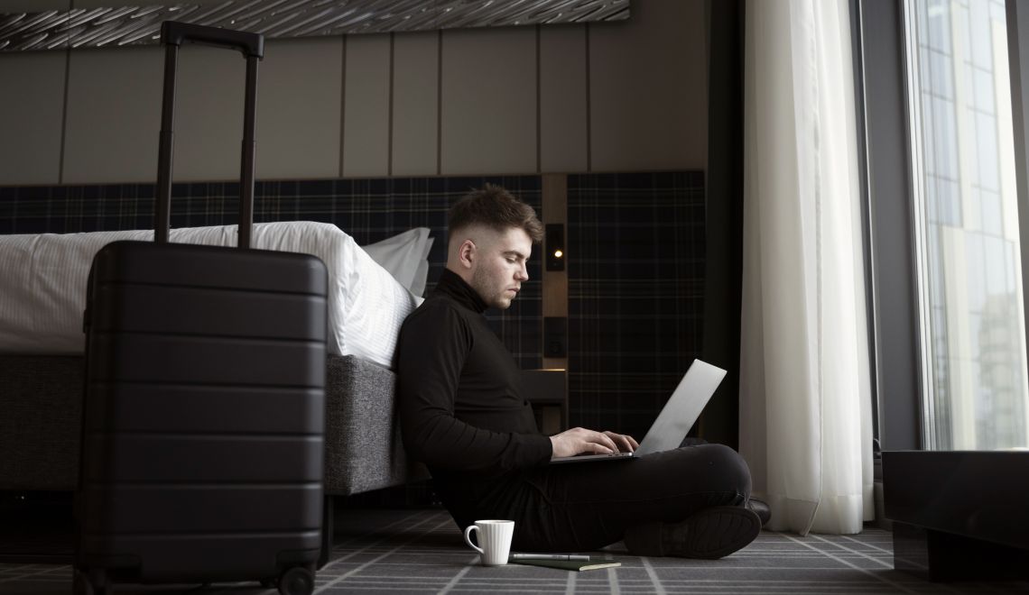 young-man-working-his-laptop-hotel-room