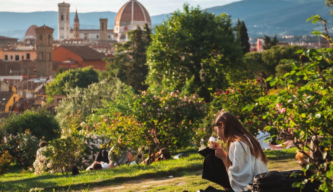Girl sitting on the grass with a beautiful view of Florence at the background